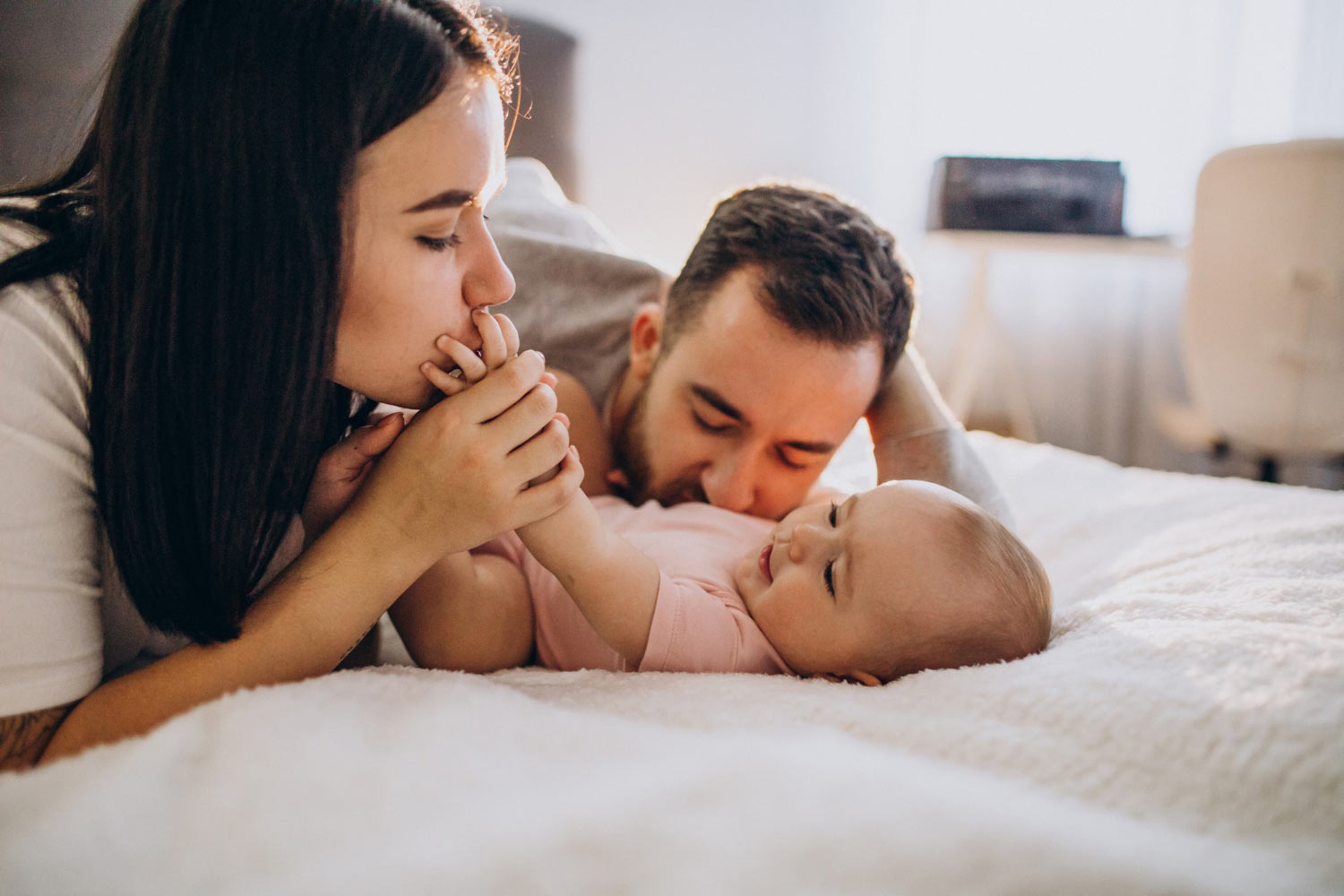 young-family-with-baby-daughter-lying-together-bed Home